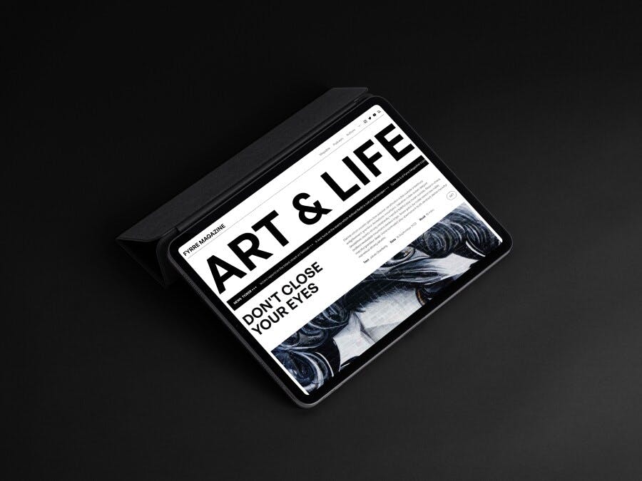 A magazine website on an iPad in horizontal orientation, resting at an angle on a dark backdrop. The title 'Art & Life' is seen in bold uppercase on the screen