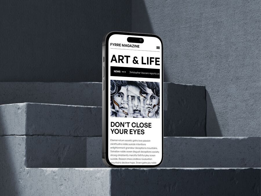 An iPhone standing upright on an elevated concrete platform with showing a magazine site on the display. The title 'Art & Life' is seen in bold uppercase on the screen